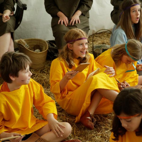 Kinder in antiker Kleidung sitzen auf dem Boden